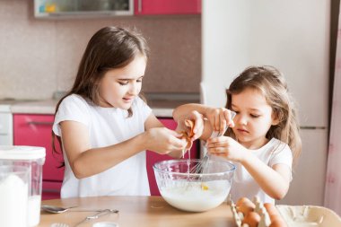 Kardeşler kahvaltı hazırlar, hamur işleri, un, süt, yumurta, gözleme kasede, çocuklar annelere yardım eder, aile kahvaltısı yapar, yemek yapar.
