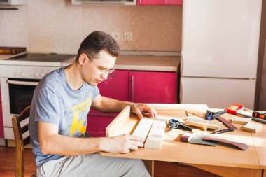 Karantinada bir adam ev, mutfak ve stüdyo için ahşap dekorlar yapar. Elleriyle, ailesiyle zaman geçirir.