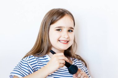 Küçük bir kız masasına oturur ve annesinin makyajıyla gözlerini ve dudaklarını boyarken, annesi evde yokken, ilk kez makyaj yapmaya çalışır, yüzünde güzellik, koronavirüs yaratır.