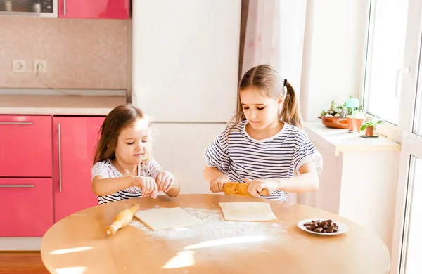 티셔츠 줄무늬가 머리를 소녀와 부엌에 자매가 밀가루 굽기를 핀으로 초콜릿을 — 스톡 사진