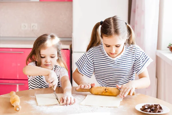 티셔츠 줄무늬가 머리를 소녀와 부엌에 자매가 밀가루 굽기를 핀으로 초콜릿을 — 스톡 사진