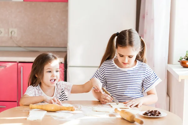 소녀와 여동생 식탁에서 밀가루와 주방에서 요리하고 아이들 요리하고 맛있는 정크푸드 — 스톡 사진