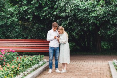 Bir kız ve bir erkek telefonda kendi fotoğraflarını çekiyorlar, cihazlar, selfie 'ler, telefonun kamerasında fotoğraf çekiyorlar, bir anı fotoğrafı, kahkaha, neşe, aşk.