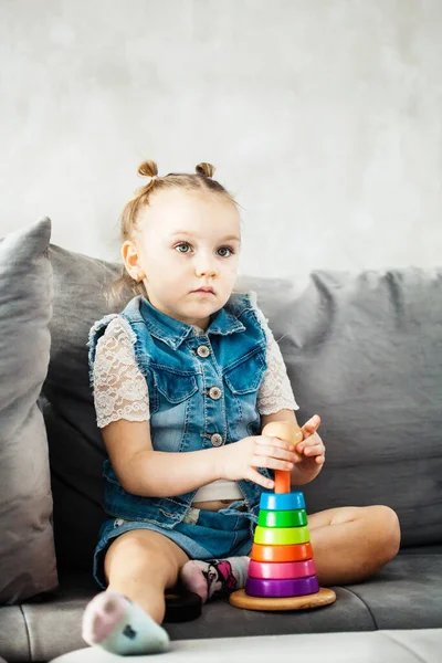 Маленькая Девочка Сидит Диване Играет Образовательные Игры Цветные Кольца Игрушка — стоковое фото