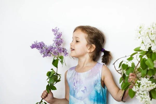 Uma Menina Fundo Branco Fica Mantém Ramos Lilás Kurst Florescendo — Fotografia de Stock