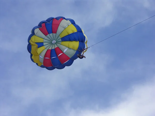 multi-colored parachute in the blue sky flie