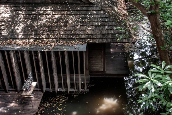 Traditional wooden house with Thatched Roof in the garden over the small canal. — Stock Photo, Image