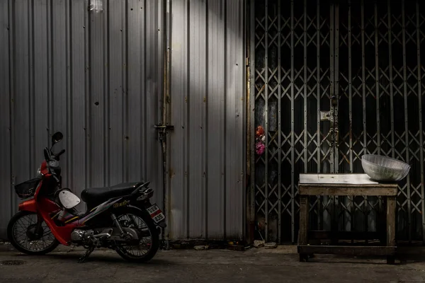 Припаркований мотоцикл і старий дерев'яний стіл перед древнім залізом. — стокове фото