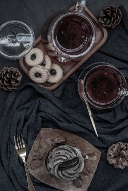 Koyu mavi kumaşlı bir fincan meyveli çayla Orio keki..