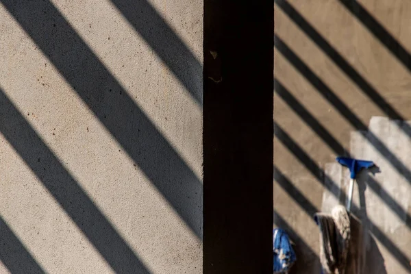 Heldere stralen van ochtendlicht schijnen door de muur, schaduwen op — Stockfoto