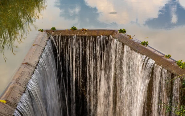 Turbid water in the check dam overflows into the spillway, Man-m — Stock Photo, Image