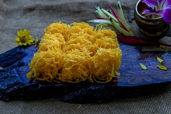 Golden egg strip is Thai desserts made from eggs on wooden backg