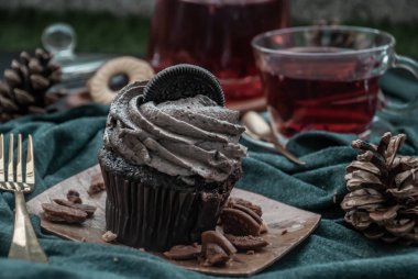 Koyu mavi kumaşlı bir fincan meyveli çayla Orio keki..