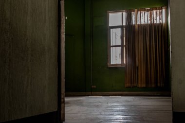 Terk edilmiş, büyük pencereli bir oda zamanla bozulmaya bırakıldı.