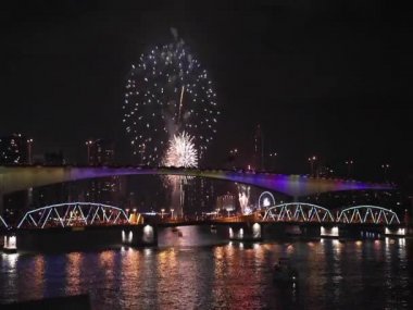 Celebration. The wobderful Fireworks light up into the sky, look through the beautiful bridges and rivers on twilight background. Sign of Celebrating New Year and special festival.