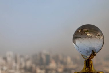 Looking through crystal globe showing an upside down skyline.
