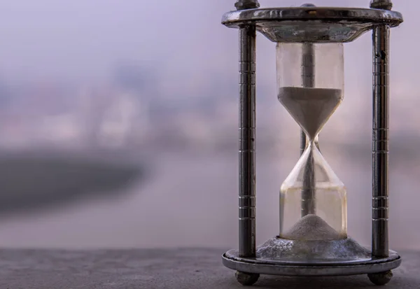 Hourglass with blur city at evening time. Beauty and past moment — Stok fotoğraf