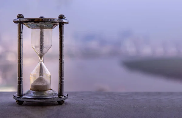 Hourglass with blur city at evening time. Beauty and past moment — Stok fotoğraf