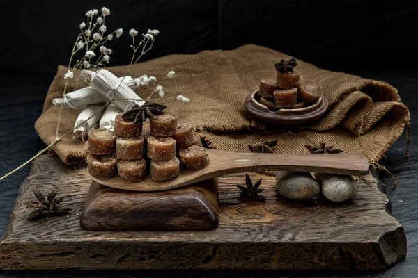 Cubo de açúcar de cana marrom em concha de madeira e saco . — Fotografia de Stock