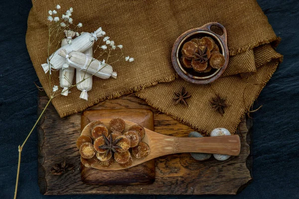 Bruine rietsuikerkubus op houten pollepel en zak. — Stockfoto