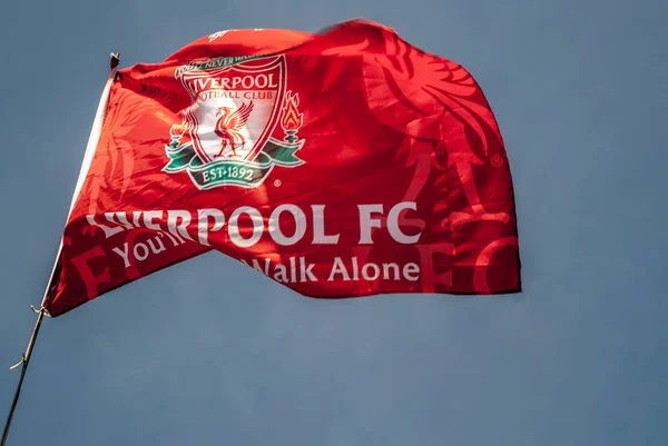 Liverpool F.C. Mavi gökyüzü arkaplanlı bayrak dalgalanması.