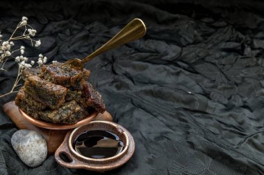 Koyu arkaplanda, ahşap tabakta tatlı siyah soya sosuyla servis edilen kızarmış Kuicheai. Çin yemeği tarzı. Boşluğu kopyala.