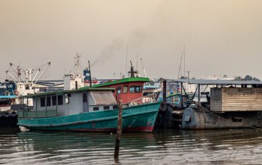 Bangkok, Tayland - 27 Şubat 2020: Küçük iskele yakınlarındaki Chao Phraya nehrinin ortasında kargo gemileri.