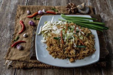 Asya yemekleri yiyen Mee Grob, beyaz tabakta tatlı ve ekşi soslu Tayland pilavlı erişteden yapılan tatlı ve ekşi bir eriştedir..