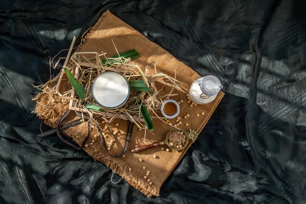 Soy products : A glass of Homemade soy milk and grains (soybeans) in wooden box Served with brown sugar and honey with lighting in the morning. Alternative milk concept, Top view, Selective focus, Copy space.