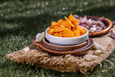 Aperatifler için çıtır sarımsaklı cips. Dilimlenmiş sarımsak, çıtır çıtır olana kadar yağda pişirilmiş ve kahverengi sarısı renkte. Yemek süsleme ve garnitür olarak ne istersen. Seçici odak.
