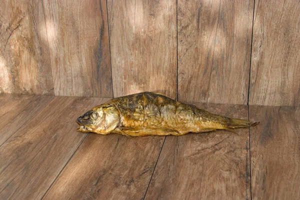 Hot smoked carp on old wooden boards. — Stock Photo, Image