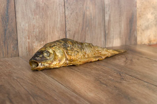 Hot smoked carp on old wooden boards. — Stock Photo, Image