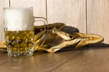 Oktoberfest tatil konsepti. Tütsülenmiş balık ve bir bardak bira. Soğuk tütsülenmiş turna balığı, koyu kırsal bir arka planda..