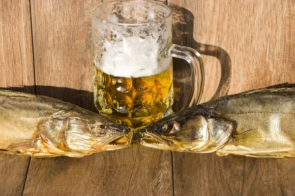 Октоберфест праздничная концепция. Копченая рыба и стакан пива. Копченая щука на тёмном деревенском фоне . — стоковое фото