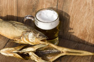 Oktoberfest tatil konsepti. Tütsülenmiş balık ve bir bardak bira. Soğuk tütsülenmiş turna balığı, koyu kırsal bir arka planda..