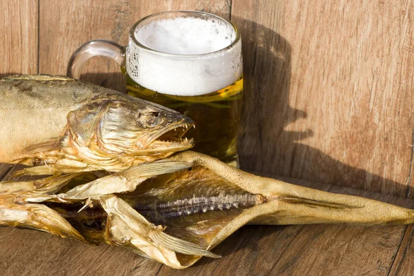 Oktoberfest ünnepi koncepció. Füstölt hal és egy pohár sör. Hideg füstölt csuka üreg sötét rusztikus háttérrel. — Stock Fotó