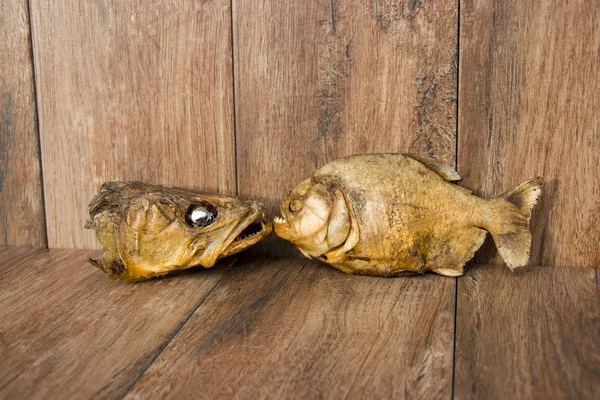 古い木の背景に魚の燻製。ピケペロピラニア川魚. — ストック写真