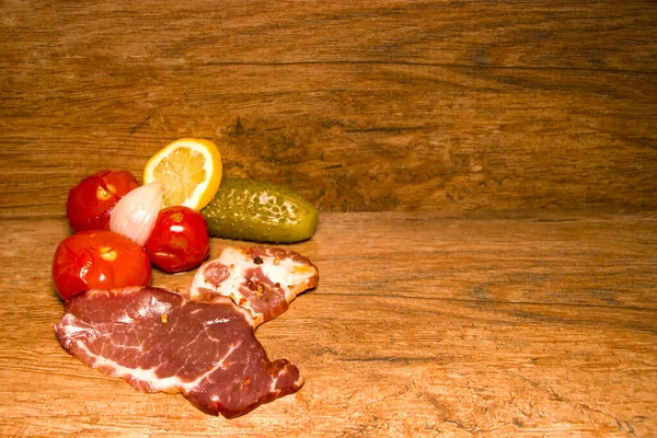 Antipasto di carne stagionato. Cetriolo sottaceto e pomodoro. Vecchio sfondo di legno . — Foto Stock