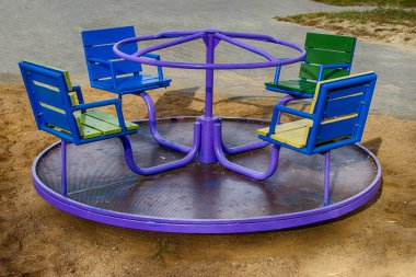 Çocuk parkı. Yuvarlak çocuk atlıkarıncasını parlak renklerle. Çok katlı bir binanın avlusunda.