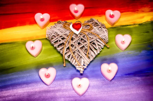Valentin-napi kártya. Nagy szív, szív alakú gyertyákkal az Lgbt zászló hátterében. Romantikus koncepció. — Stock Fotó