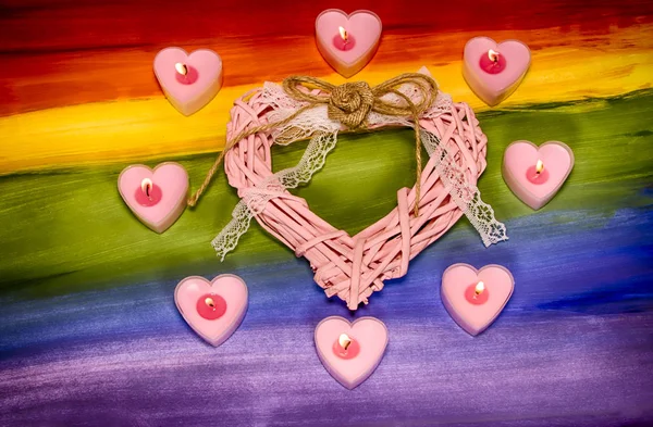 Valentin-napi kártya. Nagy szív, szív alakú gyertyákkal az Lgbt zászló hátterében. Romantikus koncepció. — Stock Fotó