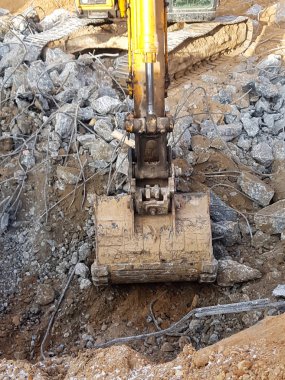 İnşaat işi, sökülüyor. Endüstriyel hidrolik çekiç kullanılarak güçlendirilmiş beton yapıların profesyonel yıkımı. Metal alaşımlı çubuklar. Beton enkazı ve kırıntıları.