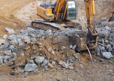İnşaat işi, sökülüyor. Endüstriyel hidrolik çekiç kullanılarak güçlendirilmiş beton yapıların profesyonel yıkımı. Metal alaşımlı çubuklar. Beton enkazı ve kırıntıları.