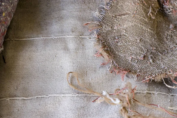 Old burlap and batting. Protruding threads. Conceptual background for design. — Stock Photo, Image