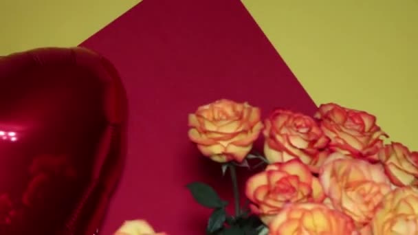 Un ballon en forme de cœur et un énorme bouquet de roses oranges flottent dans l'air. Soirée romantique. Surprise pour un être cher. Le concept d'amour et de romance . — Video