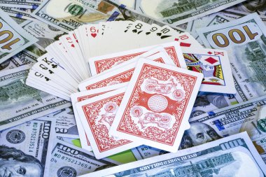 Dolar banknotlarının arka planında iskambil destesi