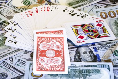 Dolar banknotlarının arka planında iskambil destesi