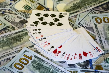 Dolar banknotlarının arka planında iskambil destesi