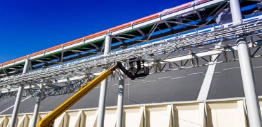 Asansör makinesi. Endüstriyel üstgeçitteki boru hattının kurulumu. İnşaat Teknolojileri. İnşaat alanı.