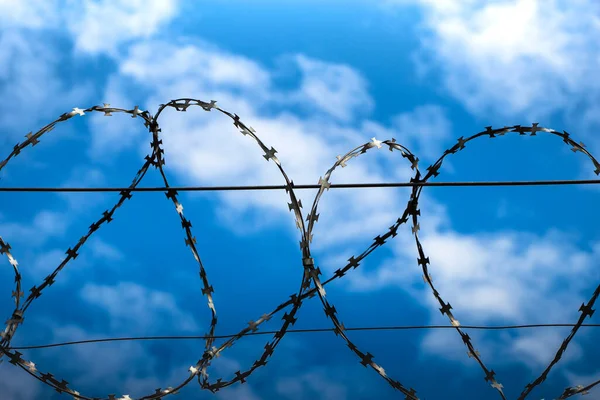 Barbed wire in the background of the cloudy sky. Concept.